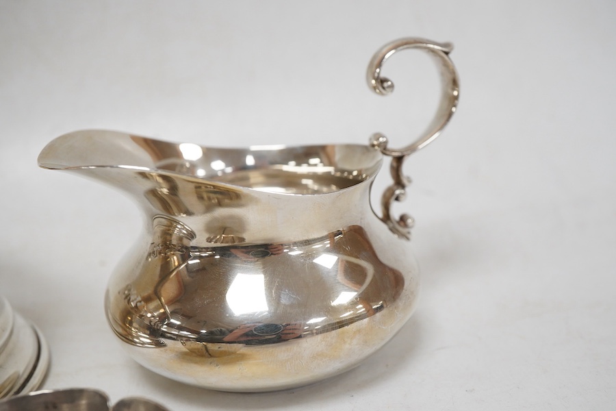An Italian pierced 900 standard white metal bottle coaster, diameter 99mm, together with a sterling cream jug and a small 925 bowl, 9.9oz.
